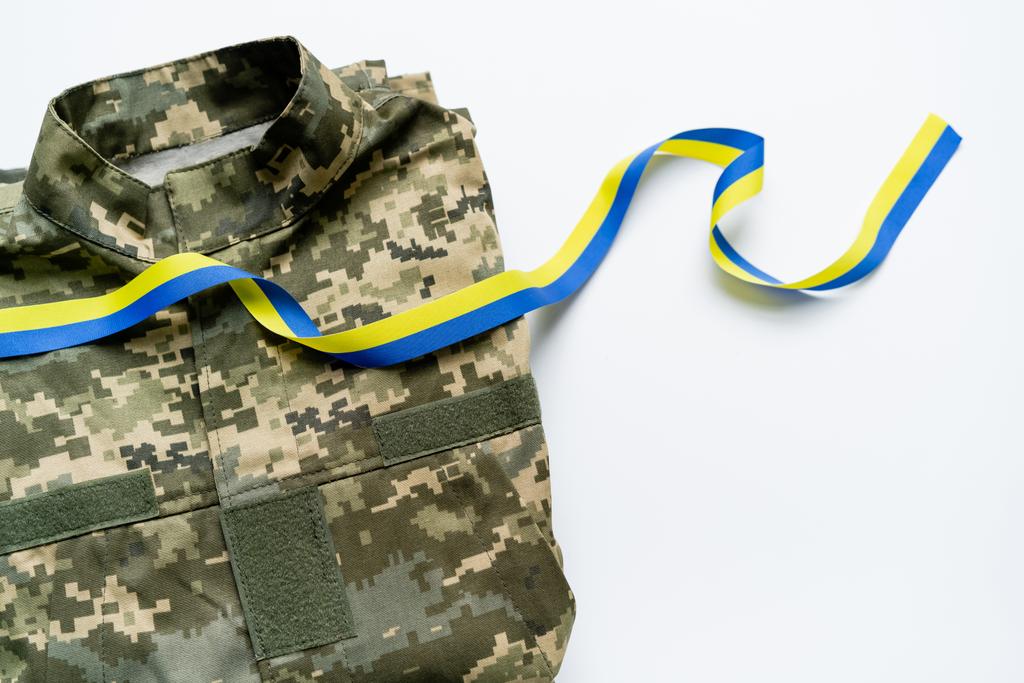 Bovenaanzicht van blauw en geel lint op militair uniform op witte achtergrond - Foto, afbeelding