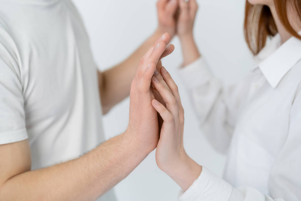 Oříznutý pohled na rozmazaný pár dotýkající se rukou izolovaných na bílém  - Fotografie, Obrázek