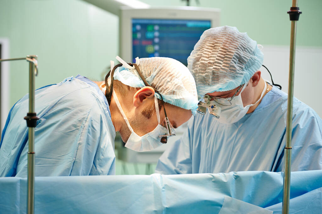 Une équipe de chirurgiens en uniforme opère un patient à la clinique de chirurgie cardiaque. Tournage authentique dans des conditions difficiles
 - Photo, image