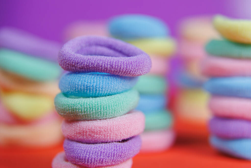 lebendige Farben rotierenden Nahaufnahme Textilgummibänder auf dem violetten Hintergrund. - Foto, Bild