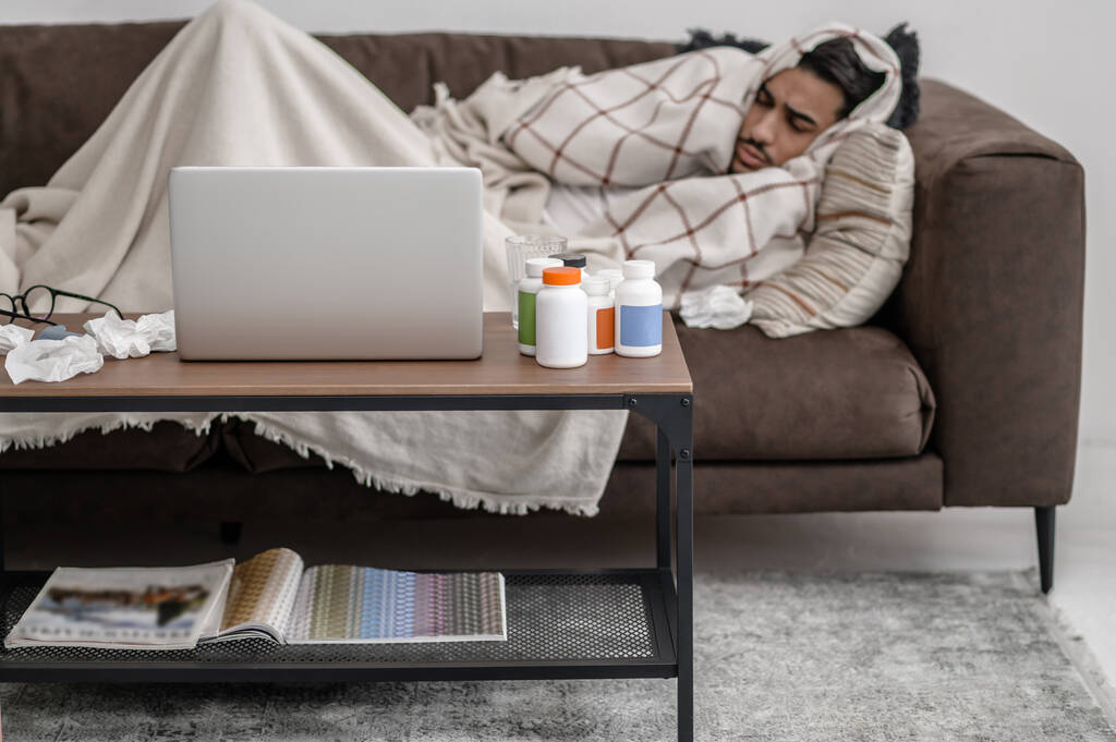 Ένας άρρωστος άνθρωπος αισθάνεται άσχημα και ξαπλωμένος στο κρεβάτι - Φωτογραφία, εικόνα