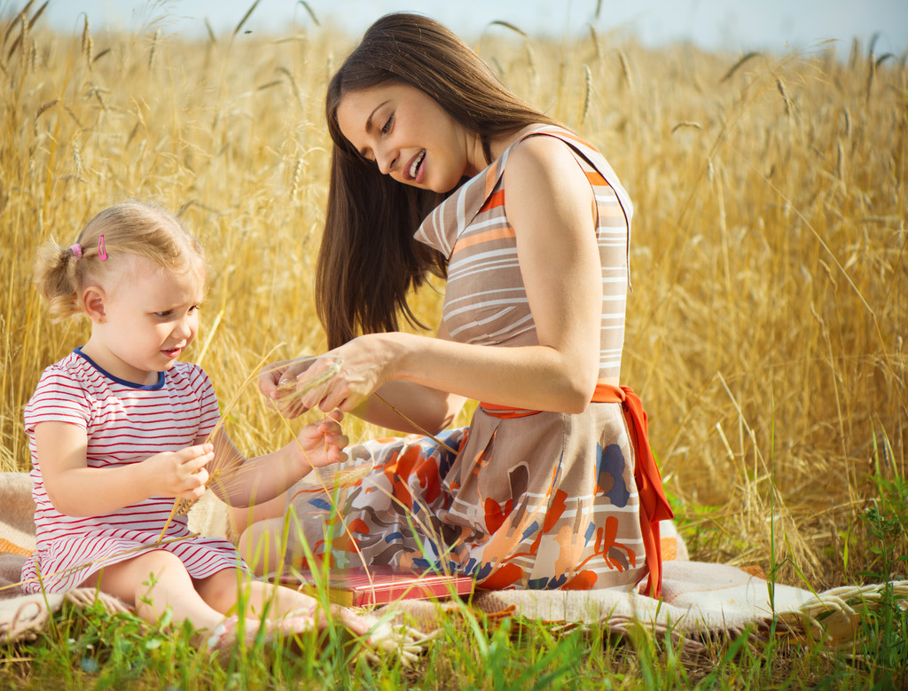 Joven madre con linda hija en el campo de trigo
 - Foto, imagen