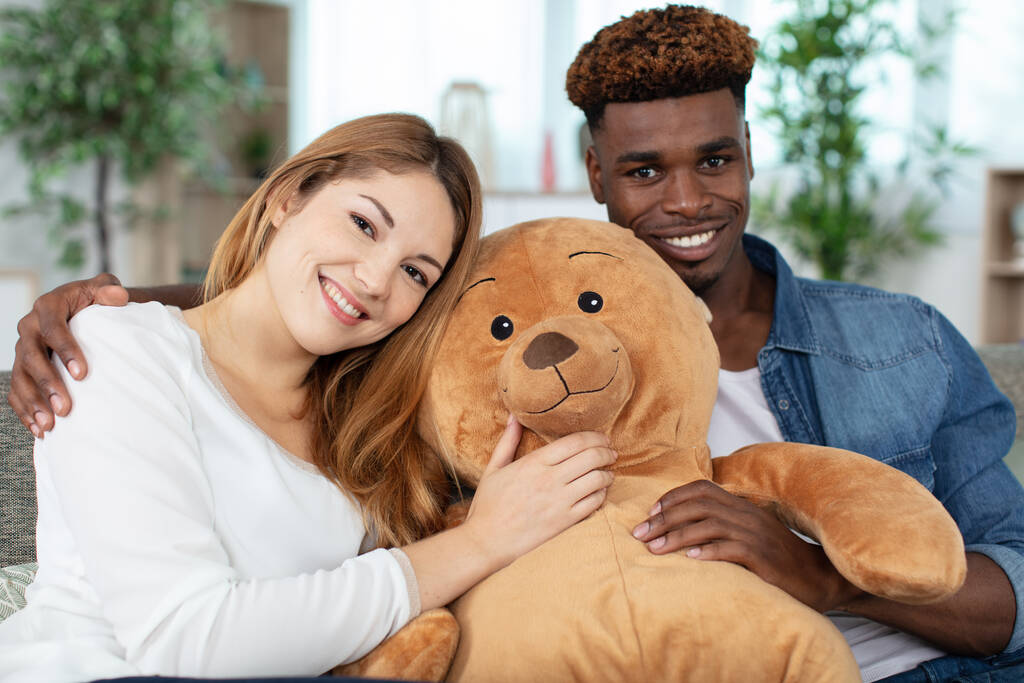 couple sat on couch with big teddy bear - Foto, Imagen