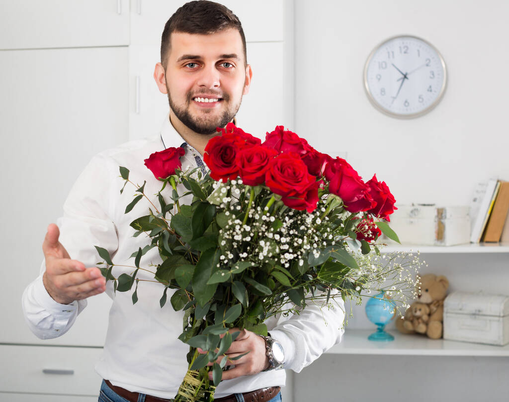 Male 29-34 years old is presenting flowers and gift - Foto, Imagen