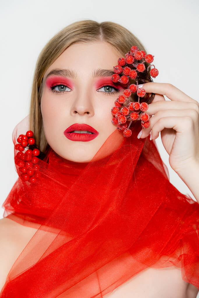 Model z makijażem i czerwony materiał gospodarstwa jagody izolowane na białym - Zdjęcie, obraz