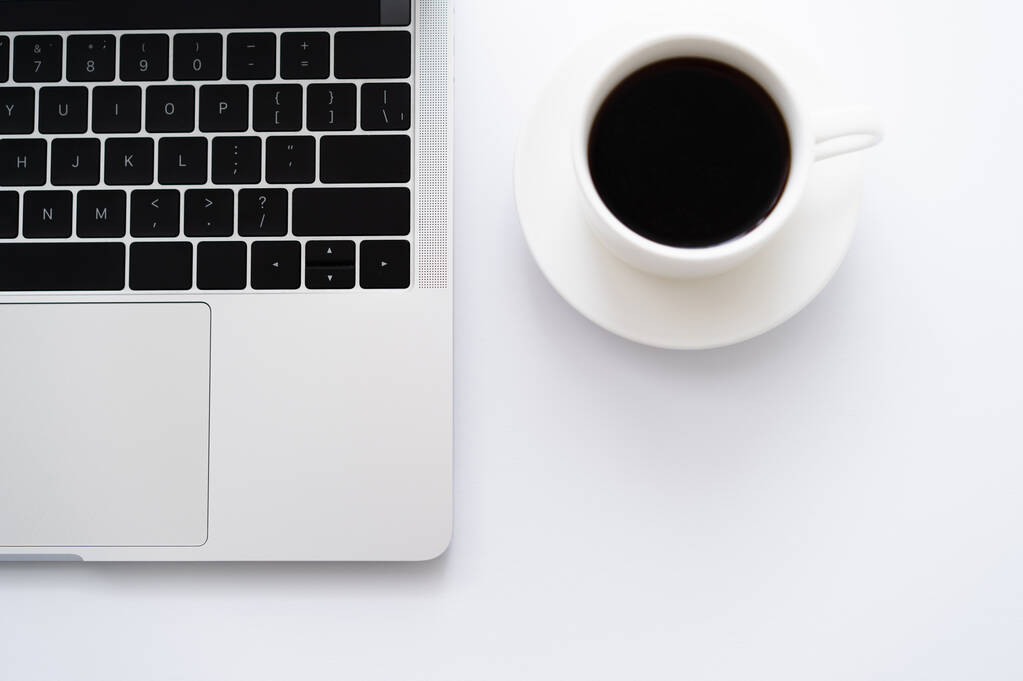 top view csésze kávé mellett laptop fehér - Fotó, kép
