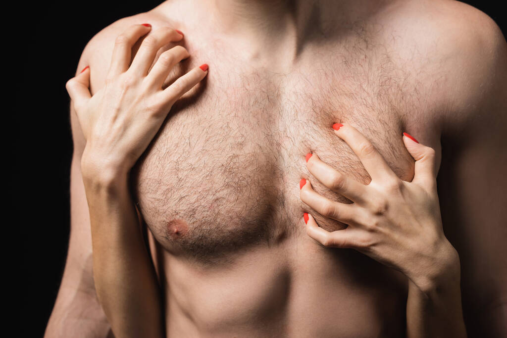 Ausgeschnittene Ansicht von Frau kratzt Brust von sexy Mann isoliert auf schwarz  - Foto, Bild