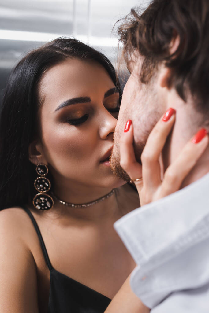 Young woman kissing boyfriend in shirt in elevator  - Foto, Imagem