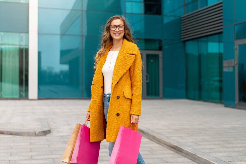 Business Woman With Shopping Bags Dressed Yellow Coat Walking Outdoors Corporate Building Tło Kaukaska Kobieta - osoba biznesowa Blisko biurowca Stylowa Bizneswoman Wyprzedaż sezonowa - Zdjęcie, obraz