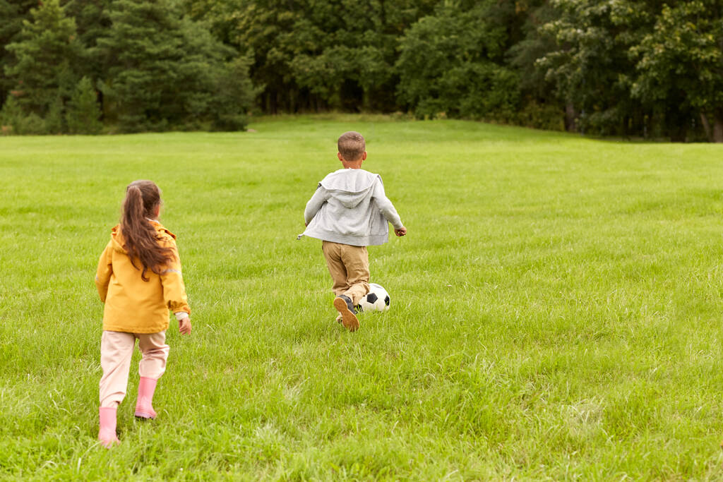 μικρά παιδιά με μπάλα παίζουν ποδόσφαιρο στο πάρκο - Φωτογραφία, εικόνα