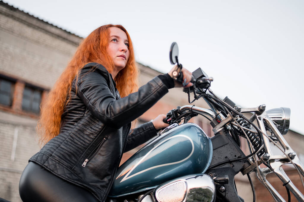 Punatukkainen kihara nainen nahkavaatteet moottoripyörä ulkona. - Valokuva, kuva
