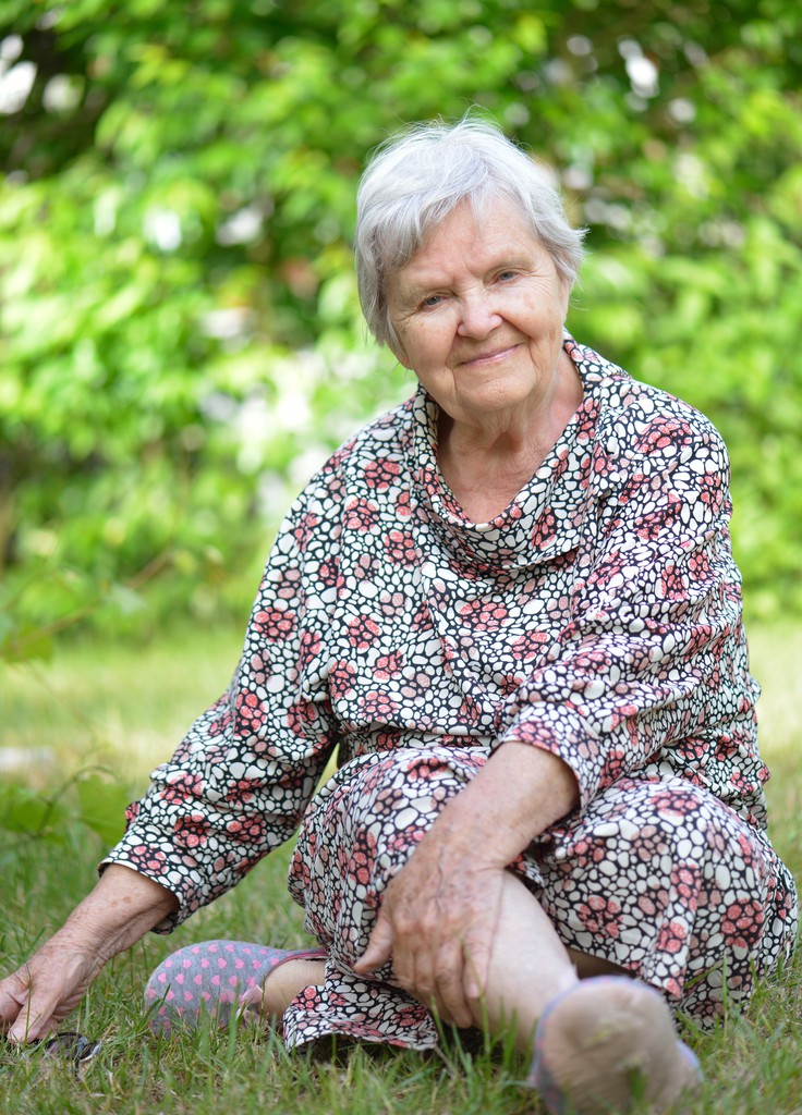 Mujer mayor sentada en la hierba. - Foto, Imagen
