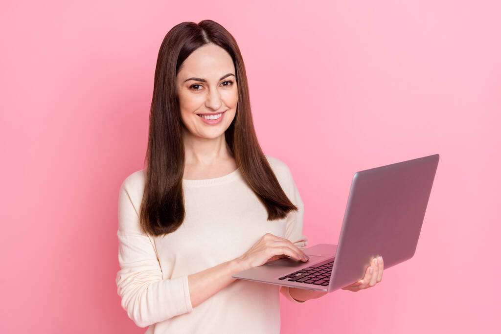 Fotografie krásné ženy to specialista držet notebook domácí výroby nosit pěkný pulovr izolované růžové barvy pozadí - Fotografie, Obrázek