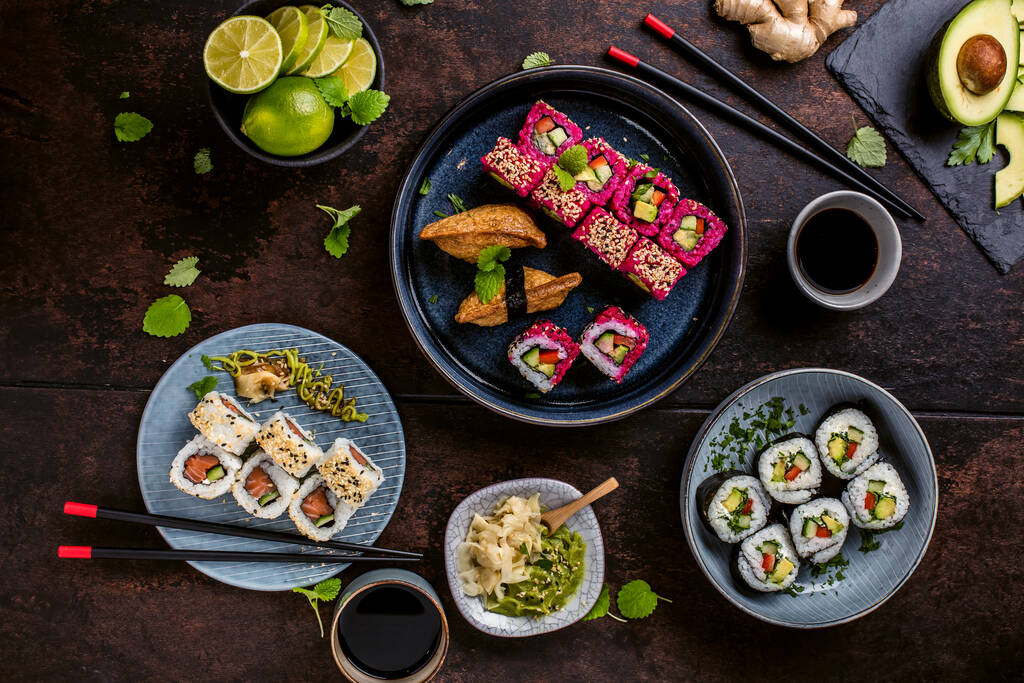 japanese sushi food. Maki ands rolls with tuna, salmon, shrimps, crab and avocado. Top view of assorted sushi. Rainbow sushi rolls, uramaki, hosomaki and nigiri. - Foto, Bild