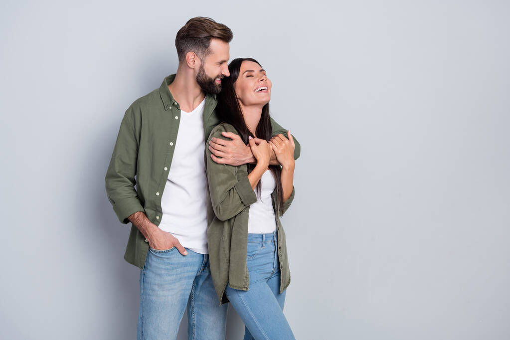 Portrait of attractive tender dreamy cheerful couple hugging laughing having fun isolated over grey pastel color background - Fotó, kép