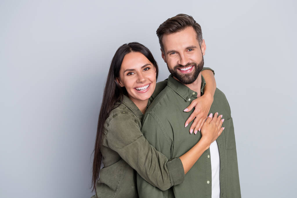 Porträt von attraktiven fröhlichen verliebten Paar besten Freunde umarmen Romantik verbringen Zeit isoliert über grau pastellfarbenen Hintergrund - Foto, Bild