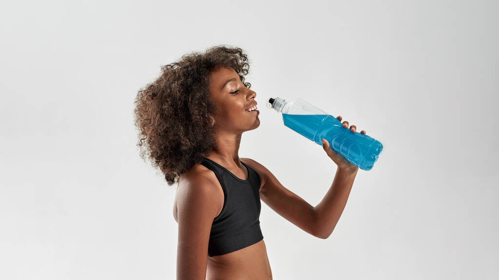 atlético negro chica beber deporte bebida de botella - Foto, imagen