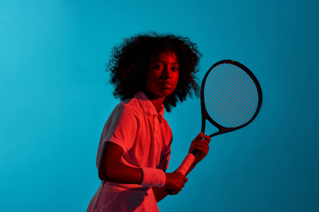 Confident black girl playing tennis with racket - Photo, Image