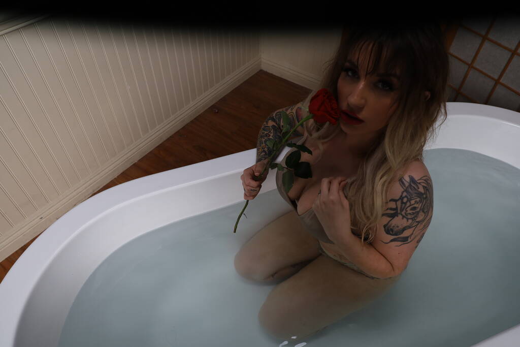 Foto van een mooi wit model zittend in een bad met een roos - Foto, afbeelding
