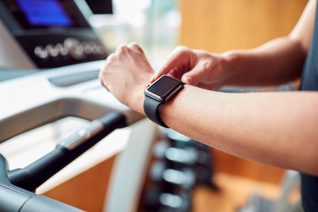 Κοντινό πλάνο της γυναίκας στο γυμναστήριο χρησιμοποιώντας Fitness App για Smart Watch on Running Machine - Φωτογραφία, εικόνα