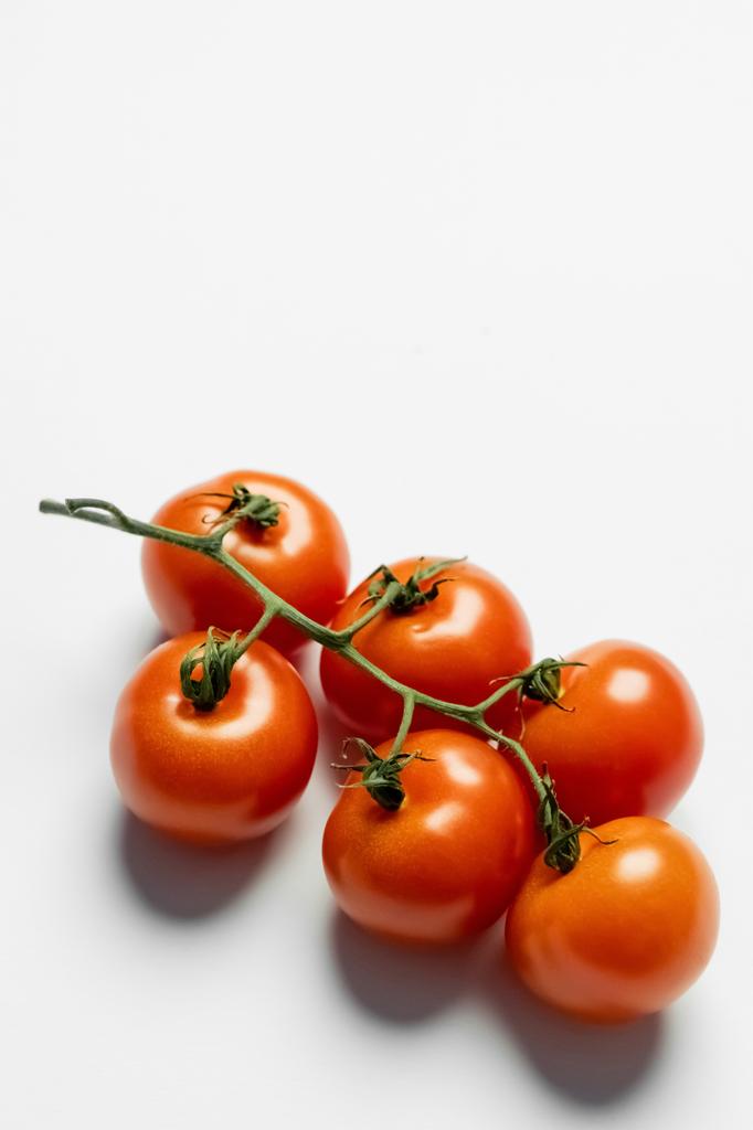 Close up view of fresh cherry tomatoes on brunch on white background  - Foto, Imagem
