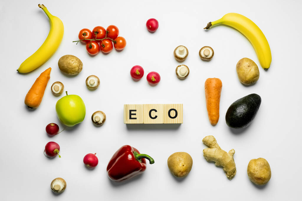 Top view of cubes with eco lettering near organic food on white background  - Фото, изображение