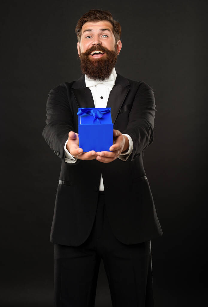 щасливий чоловік в тукседо бант краватки офіційний одяг на чорному тлі з коробкою. валентинки день
 - Фото, зображення