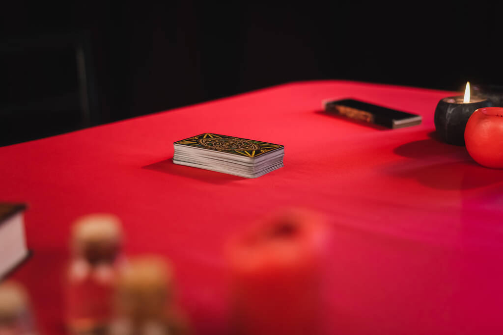 QUIIV, UCRÂNIA - FEVEREIRO 23, 2022: Cartas de tarô perto de velas e suprimentos de bruxaria borrada na mesa isolada em preto  - Foto, Imagem
