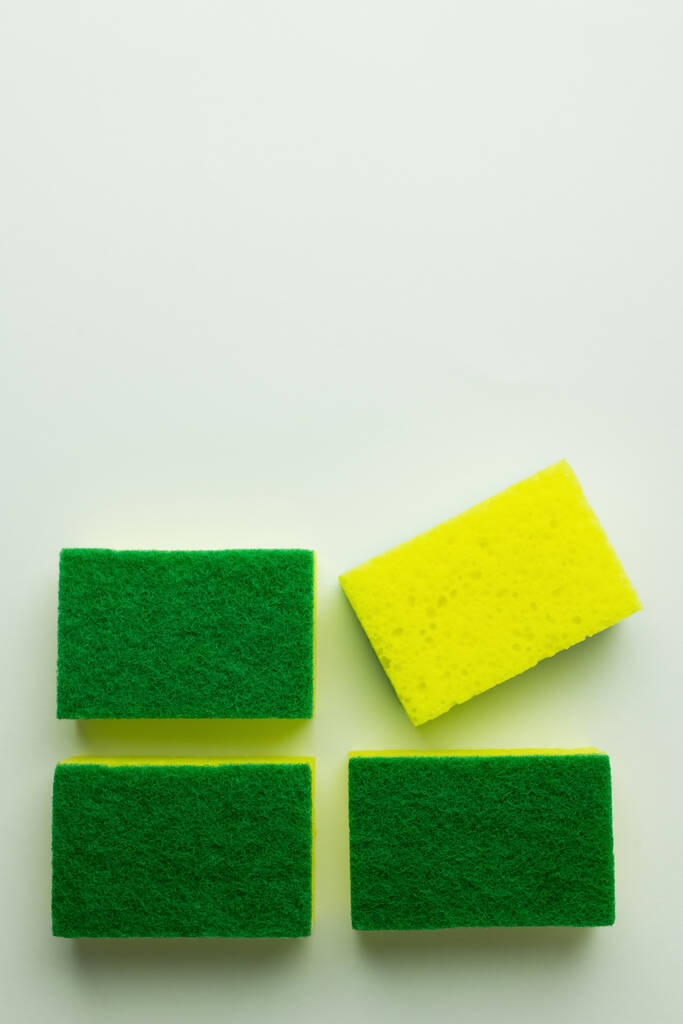 top view of yellow and green sponge scourers on grey background - Photo, image