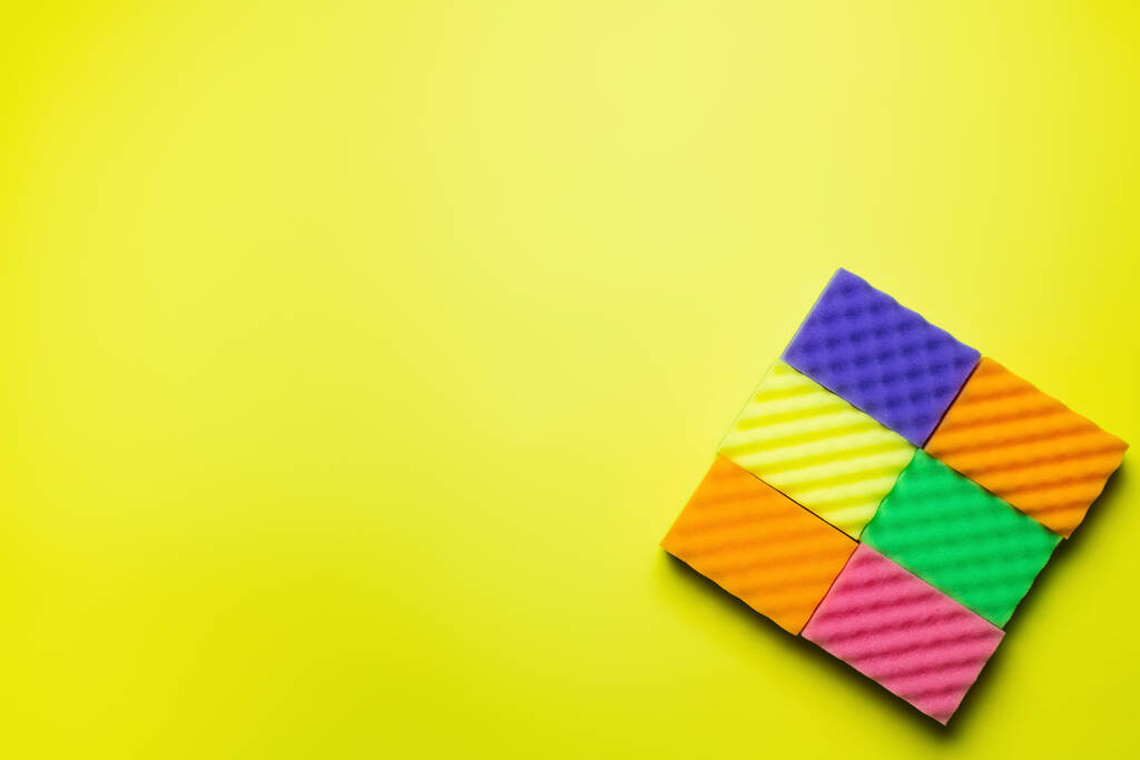 top view of textured multicolored sponges on bright yellow background - Photo, image