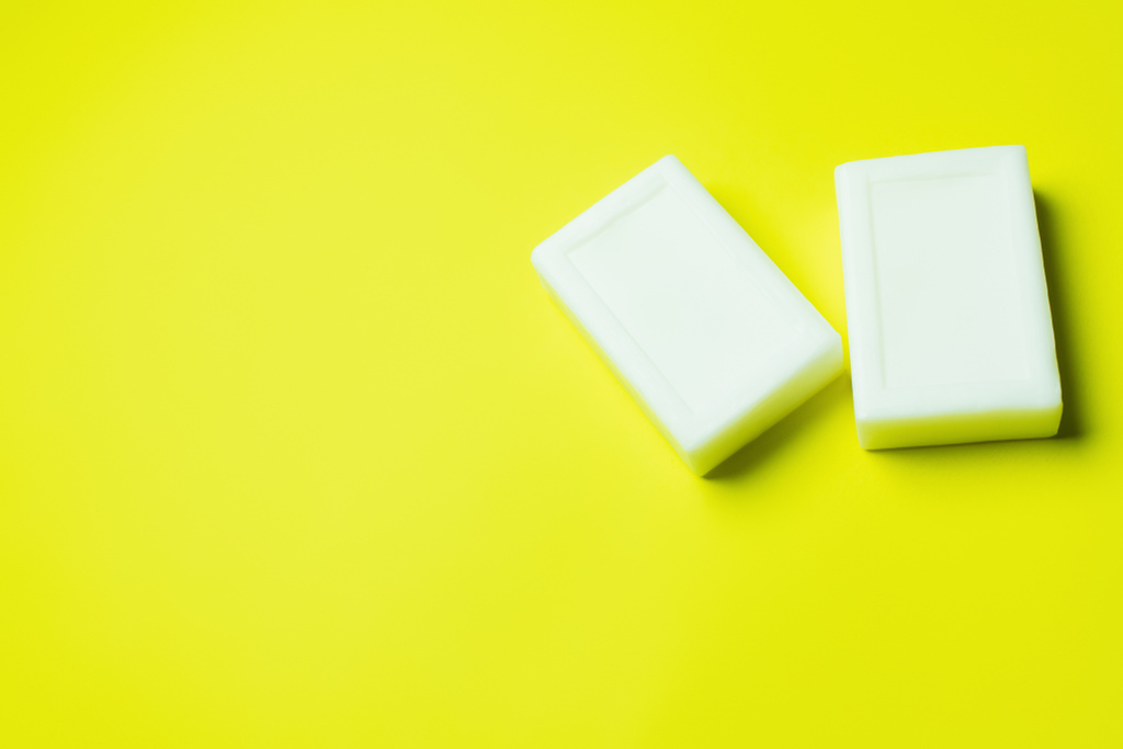 top view of white toilet soap on yellow background with copy space - Фото, изображение