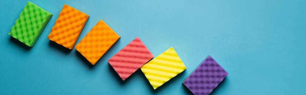 top view of soft colorful sponges on blue background, banner - Foto, afbeelding