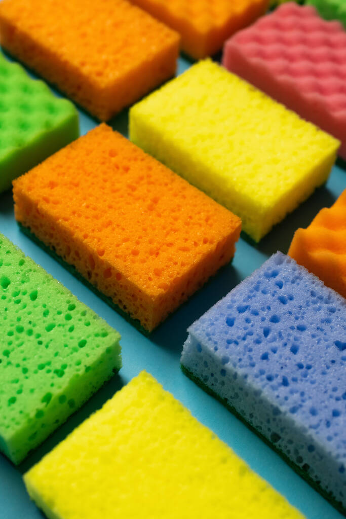porous multicolored sponge scourers on blue background - Fotó, kép
