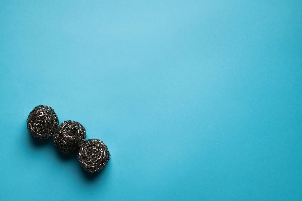 top view of three metal wire scourers on blue background with copy space - 写真・画像