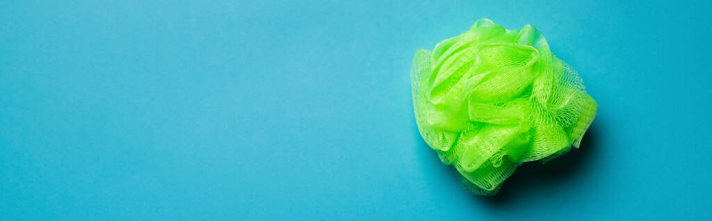 top view of bright green body washcloth on blue background with copy space, banner - Photo, Image