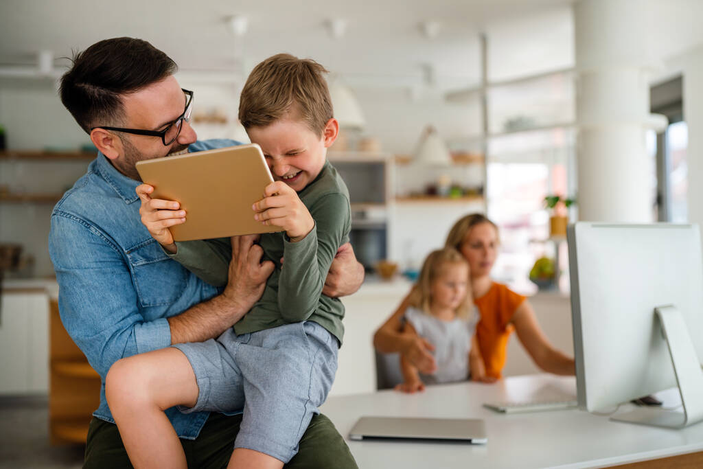 Digitaalinen laite teknologia perhe verkossa koulutus käsite. Onnellinen nuori perhe digitaalisten laitteiden kanssa kotona. - Valokuva, kuva