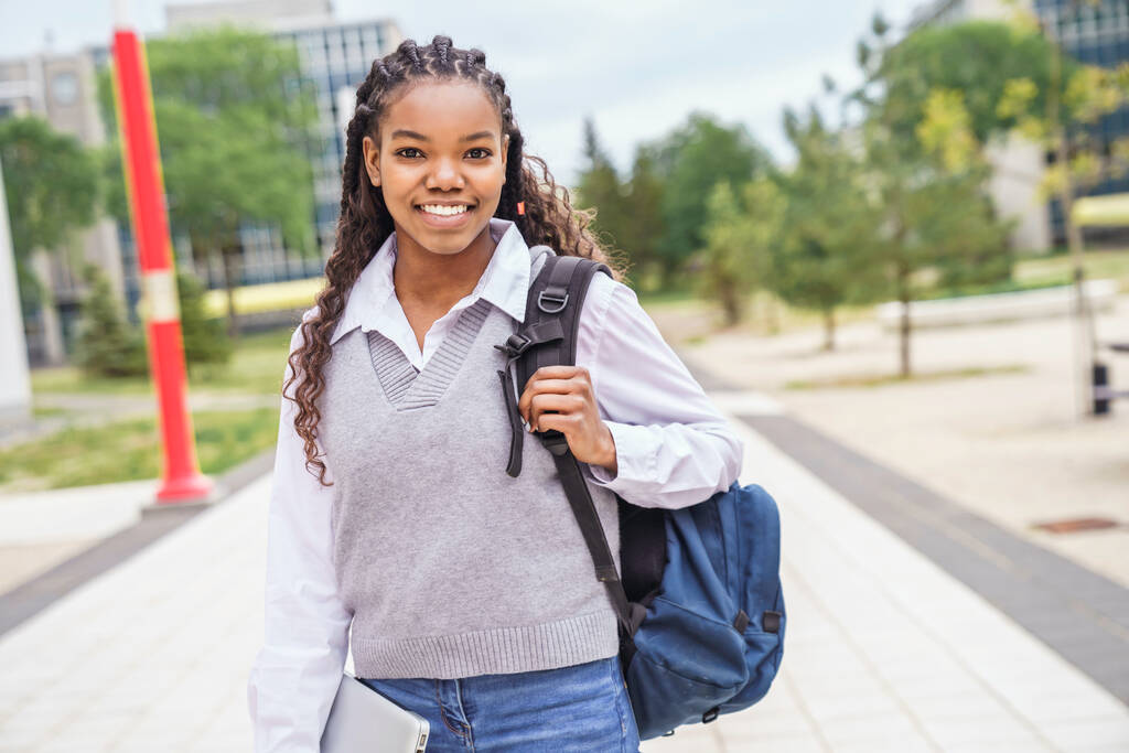 cute black teenager university student on campus with backpack - 写真・画像