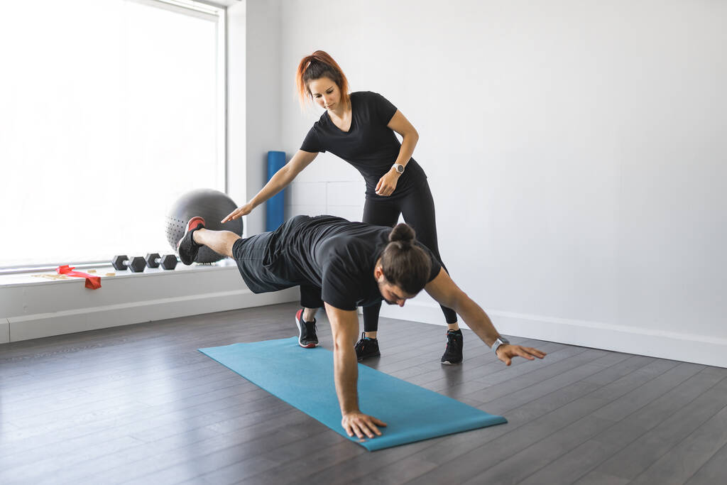 Trainerin und Klient besprechen ihre Fortschritte im Fitnessstudio - Foto, Bild