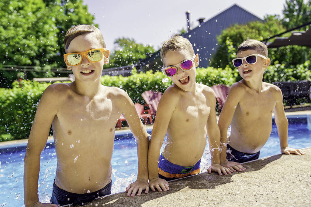 Los niños que juegan en la piscina en la hora de verano - Foto, imagen