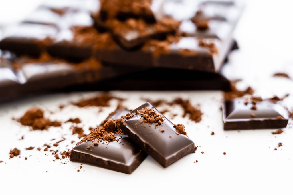 Cerrar ver piezas de chocolate marrón y cacao sobre fondo blanco  - Foto, Imagen