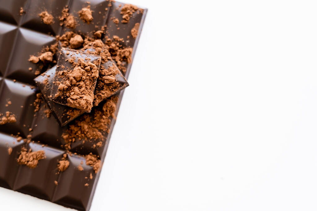 Top view of cocoa powder on dark chocolate on white background  - Foto, Bild