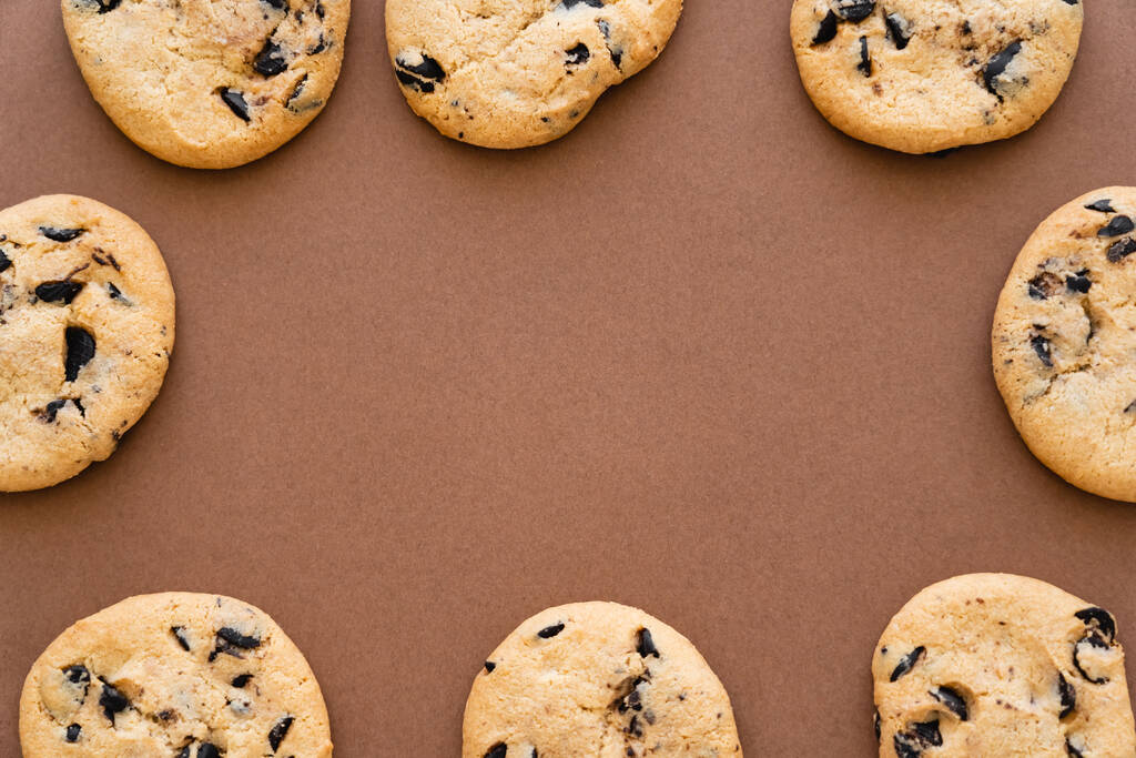 Top view of frame from cookies with chocolate chips on brown background  - Foto, Imagen
