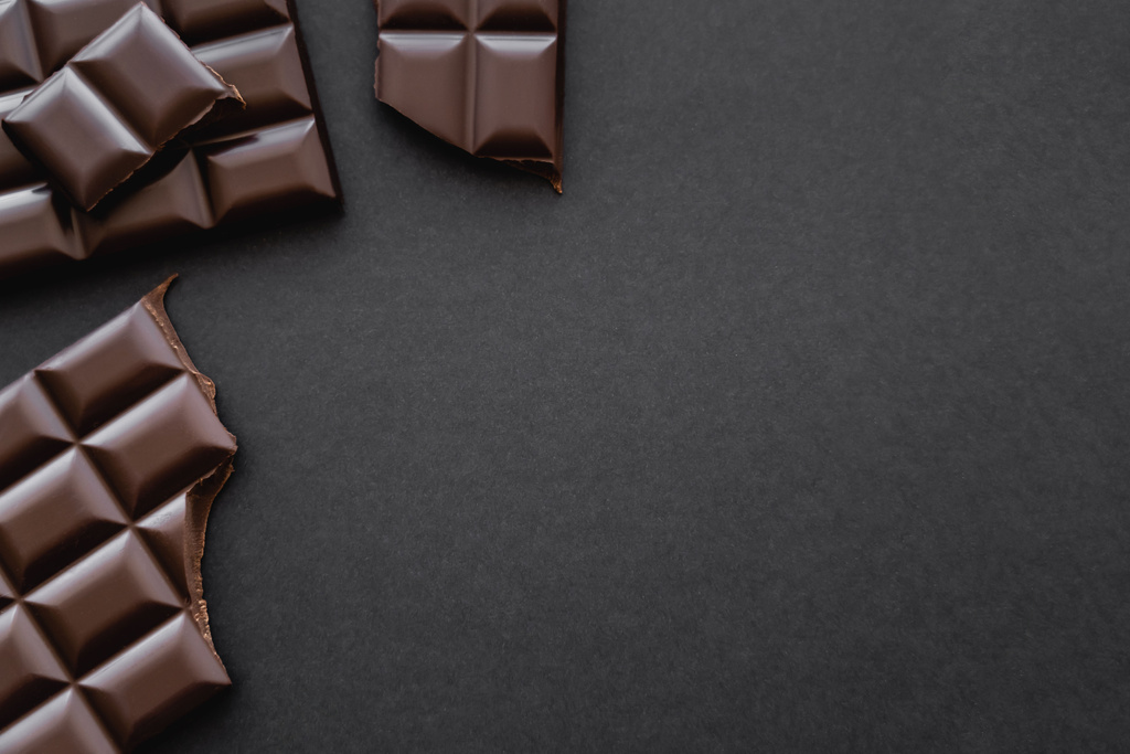 Top view of dark chocolate on black surface with copy space - Photo, Image