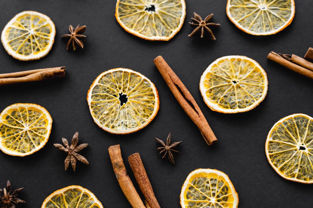 Top view of dry orange slices, cinnamon and anise on black background  - Фото, изображение