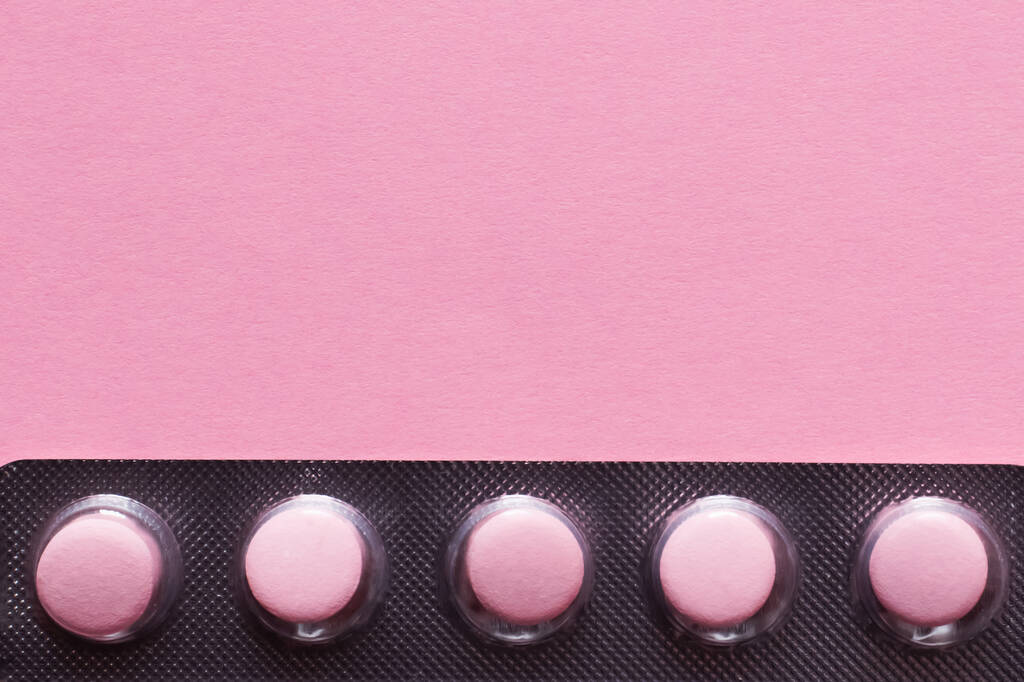 ピンクに隔離された錠剤でブリスターパックを間近で見ることができます - 写真・画像