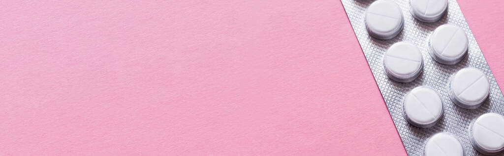 ピンクのバナーに白い丸い丸形の丸薬でブリスターパックを間近で見ることができ - 写真・画像