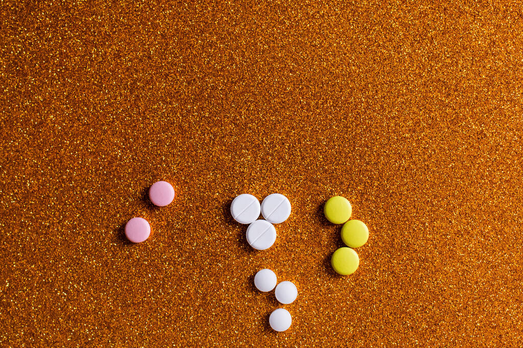 vista dall'alto di diverse pillole di forma rotonda colorate su sfondo lucido  - Foto, immagini