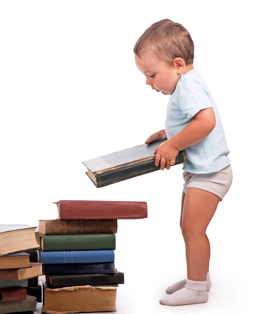 Chico se para cerca de una pila de libros para un retrato educativo - aislado sobre fondo blanco - Foto, imagen