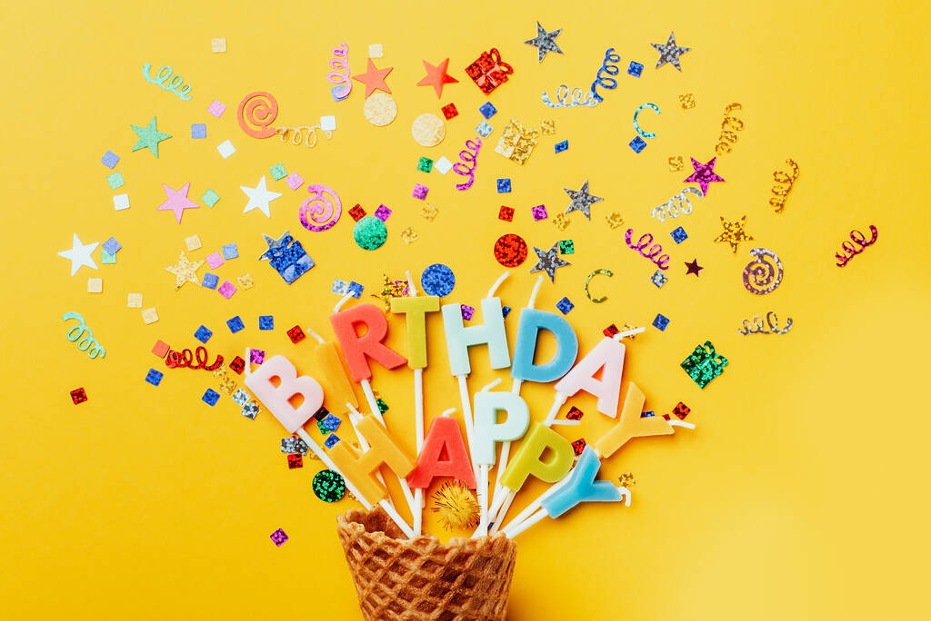 party achtergrond met tekst Gelukkige verjaardag door kleurrijke kaarsen met confetti op oranje achtergrond. - Foto, afbeelding