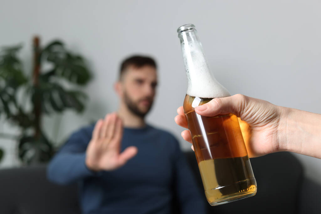 Man refusing to drink beer indoors, closeup. Alcohol addiction treatment - Foto, Imagem